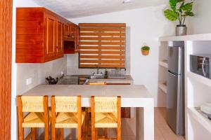 a kitchen with wooden cabinets and a table with chairs at Casa Rincón Bonito in Puerto Escondido