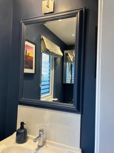 a bathroom with a mirror above a sink at Charming cottage in Urchfont +10 photos