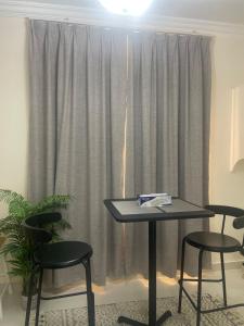 a table and two chairs in front of a window at Seaside Two Bedroom Charming Apt in Salalah