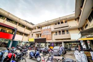 Un grupo de motocicletas estacionadas frente a un edificio. en Collection O Suvidha, en Bilāspur