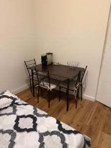 a table and chairs in a room with a bed at Maisonnette in Aulnay-sous-Bois