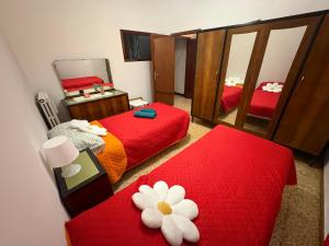 a bedroom with two beds and a mirror at La casa di Nonna nel Piazzalino Asciano Siena Crete Senesi in Asciano