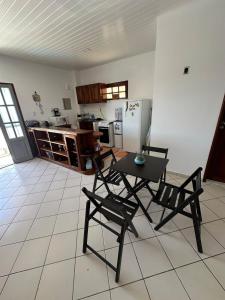 cocina con 2 sillas, mesa y nevera en Apartamento Janelas do Atlântico Praia do Atalaia PA, en Salinópolis