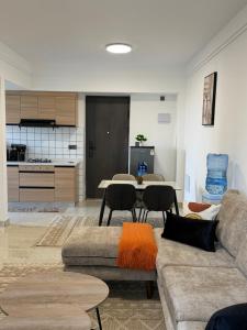 a living room with a couch and a table with chairs at Tranquil Haven by the UN Ruaka 1BR with Pool &Gym in Ruaka