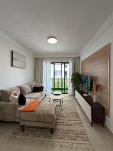 a living room with a couch and a table at Tranquil Haven by the UN Ruaka 1BR with Pool &Gym in Ruaka
