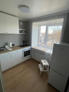 a small kitchen with white cabinets and a window at Apartment in the city centre of Tapa in Tapa