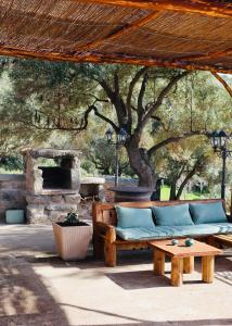 a patio with a couch and a table and a tree at Bergerie de Charme Pedi Lione in Calvi