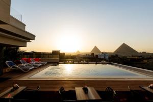 カイロにあるKemet Pyramids View Hotelのピラミッドのある建物の屋上にあるプール
