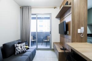 ein Wohnzimmer mit Sofa und Fernseher in der Unterkunft Casa Pantuso no coração de BH in Belo Horizonte