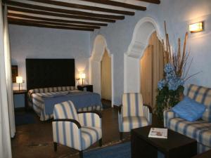 a hotel room with a bed and chairs and a table at La Casona del Solanar in Munébrega