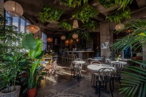a restaurant with tables and chairs and plants at Nordic Hostel in Reykjavík