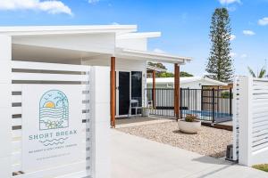 a white shop break sign in front of a white building at 'Short Break' - Luxurious Coastal Retreat with Pool and BBQ in Urangan