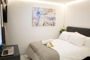 a bedroom with a bed and a laptop on a table at Willow Brooks in Cape Town