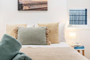 a bedroom with a bed with a green pillow at 'Short Break' - Luxurious Coastal Retreat with Pool and BBQ in Urangan