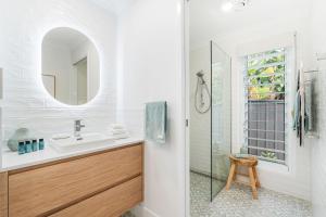 a bathroom with a sink and a mirror at 'Short Break' - Luxurious Coastal Retreat with Pool and BBQ in Urangan +12 photos