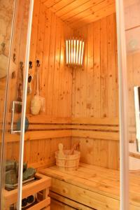 a sauna with a wooden wall and a chandelier at Start Apartments LUX KOPAONIK in Kopaonik