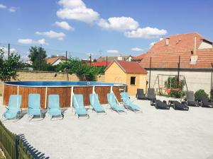 eine Gruppe von Stühlen auf einer Terrasse mit einem Pool in der Unterkunft Penzion Siesta in Valtice
