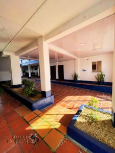 an empty lobby of a building with pillars and plants at Hotel colombia in Tolú
