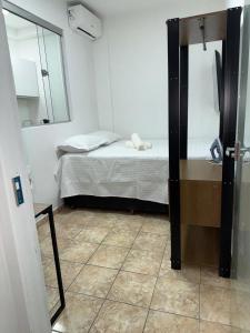 a small room with a bed and a mirror at Studio Apartment - Bom Retiro - S04 in Ipatinga