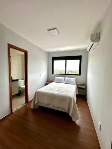 ein Schlafzimmer mit einem weißen Bett und einem Fenster in der Unterkunft Apto Moderno com 2 quartos em Londrina in Londrina + 37 Fotos