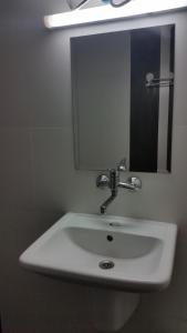a white sink in a bathroom with a mirror at 4U Apartment in Burgas City