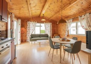 Una cocina y una sala de estar con mesa y sillas. en Chaletparc Krabbenkreek Zeeland - Chalet 130, en Sint Annaland 12 fotos más