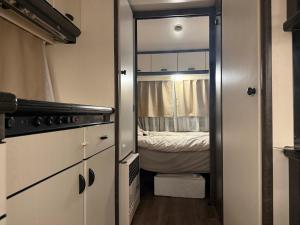 Un dormitorio pequeño con una cama y un espejo. en Fully Equipped Caravan 1, en Gentofte