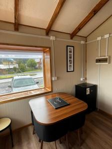 uma pequena sala com uma mesa e uma janela em Cabaña Puerta a la Patagonia em Chaitén