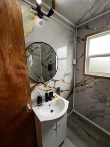 um banheiro com uma pia e um espelho em Cabaña Puerta a la Patagonia em Chaitén mais 6 fotografias