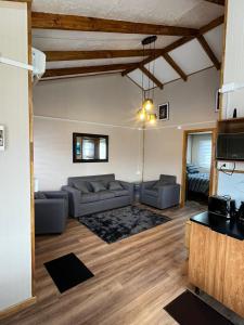a living room with two couches and a tv at Cabaña Puerta a la Patagonia in Chaitén