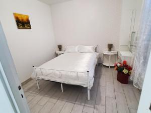 a bedroom with a white bed and two night stands at Le Refuge Nature à 20 min de Paris et d'Orly via RER Juvisy in Draveil
