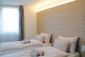 two beds in a room with white pillows at Locanda Marco in Bellinzona +21 photos
