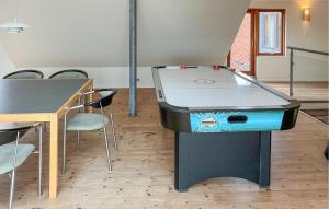a ping pong table in a room with chairs at 4 Bedroom Beach Front Home In Vinderup in Vinderup +22 photos