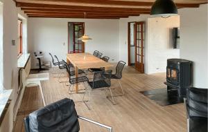 a dining room with a table and chairs and a stove at 4 Bedroom Beach Front Home In Vinderup in Vinderup