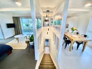 a room with a staircase leading to a kitchen and a dining room at Treetop studio apartment in Hamilton
