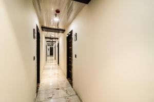 an empty corridor with white walls and a ceiling at Hotel O JPS Galaxy Hotel in New Delhi