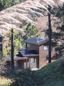 een huis met een zonnedak op een heuvel bij La Colina de Villa Yacanto in Villa Yacanto