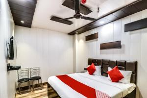a bedroom with a bed with red pillows at Hotel O JPS Galaxy Hotel in New Delhi +16 photos