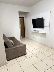 a living room with a couch and a flat screen tv at Kitnet - Centro - Ipatinga in Ipatinga