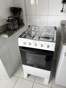 a white stove top oven in a kitchen at Kitnet - Centro - Ipatinga in Ipatinga +16 photos
