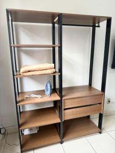 a book shelf with wooden shelves in a room at Kitnet - Centro - Ipatinga in Ipatinga