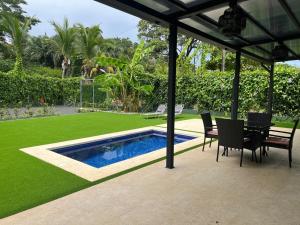 a patio with a table and chairs and a swimming pool at Casa Flor in Playa Avellana