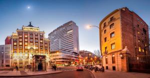 a city street with buildings and a car on the street at Melia Madrid Princesa in Madrid