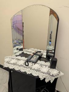 a desk with a mirror and a phone on it at Ocean Breeze Apartments in Dar es Salaam