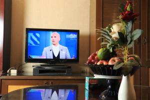 a television sitting on a table with a man on the screen at Sea Shell Hotel - Sales & Booking Office in Bāiljuri