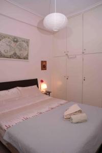 ルートラキにあるLucy's comfy apt in town centre by the seaの白いベッドルーム(ランプ付きの大型ベッド1台付)