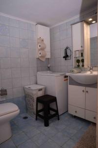 ルートラキにあるLucy's comfy apt in town centre by the seaのバスルーム(トイレ、シンク、スツール付)