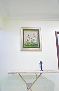 una pintura de flores rosas en una pared blanca en Two Bedrooms Standby Generator DSTV Netflix W-iFi, en Takoradi