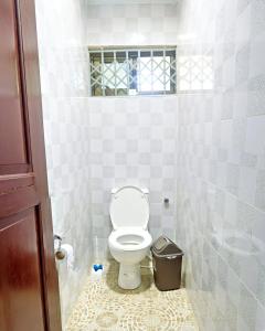 een badkamer met een toilet en een vuilnisbak bij Two Bedrooms Standby Generator DSTV Netflix W-iFi in Takoradi +12 foto's