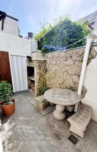 une terrasse en pierre avec une table et une cheminée en pierre dans l'établissement Check and Home - Casa San Luis - 6 Huéspedes en Barrio Chauvin, à Mar del Plata